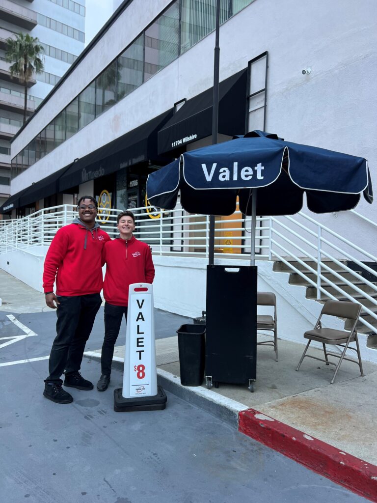 Two people standing together near a valet board